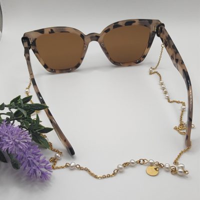 Chaîne à lunettes - Perles d'agate roses entourées et entrelacées de perles de rocailles dorées - présentée sur lunettes