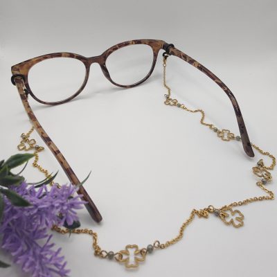 Chaîne à lunettes - Motifs trèfles à 4 feuilles dorés et perles de verre vertes pastelles - présentée sur lunettes
