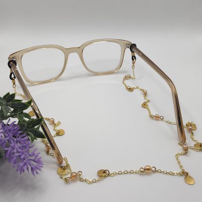 Chaîne à lunettes - Perles d'agate roses entourées et entrelacées de perles de rocailles dorées - présentée sur lunettes