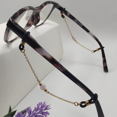 Bijoux de branches - Perle de verre plate rose pastelle entourée de perles dorées - Présentation sur lunettes